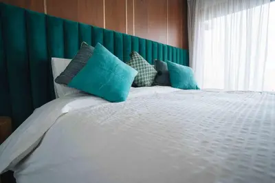 a bedroom with a white bed with blue pillows at Luxury Villa Jack Beach Resort Pool & Seaview in Tamaris