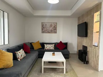 a living room with a couch and a tv at Vivez Une Expérience Unique à ARMADA in Bouznika
