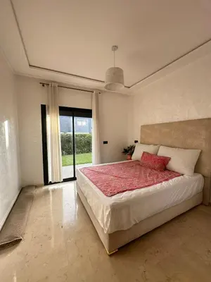 a bedroom with a large bed and a large window at Logement luxueux avec 2 piscines in Dar Hamida