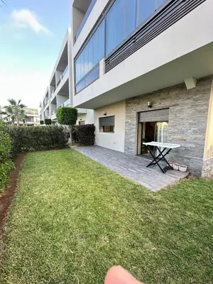 a backyard with a picnic table in front of a building at Logement luxueux avec 2 piscines in Dar Hamida