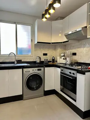 a kitchen with a washing machine and a sink at Appartement chic - Princesses in Casablanca