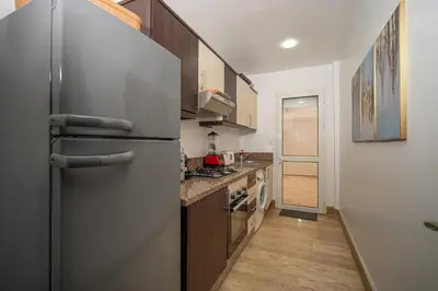 a kitchen with a stainless steel refrigerator and wooden cabinets at Studio chic- les princesses Maarif in Casablanca