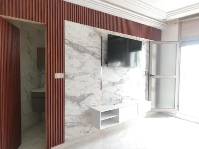 a bathroom with a sink and a television on a wall at Charmant appartement à Casablanca Près tram & gare in Casablanca