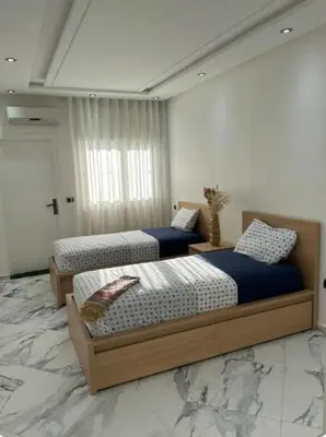 three beds in a room with marble floors at Rabat Agdal apartment in Rabat