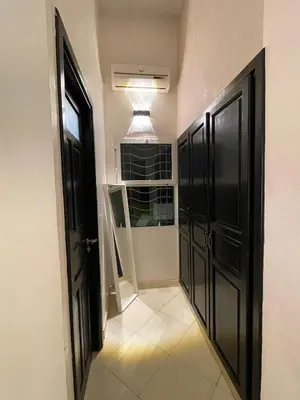 a hallway with black doors and a tiled floor at 2-bedroom duplex for rent in Temara