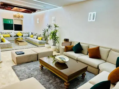 a living room with couches and a coffee table at Villa de luxe avec piscine et jardin privés in Temara