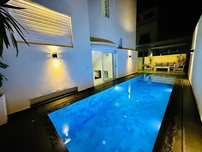 a large swimming pool in the middle of a house at Villa de luxe avec piscine et jardin privés in Temara