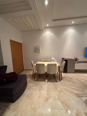 a living room with a table and chairs and a couch at Casabay kettani sidi rahal in Sidi Rahal