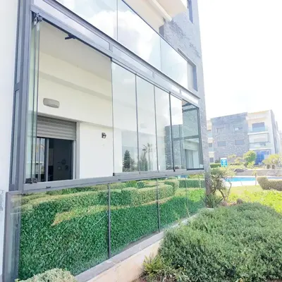 an external view of a building with large glass windows at Appartement Tamaris avec piscine et plage privée in Casablanca