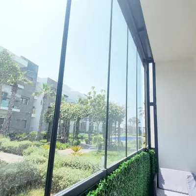a window in a building with a view of a courtyard at Appartement Tamaris avec piscine et plage privée in Casablanca