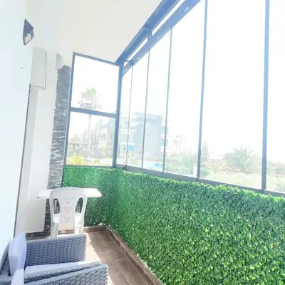 a green hedge in a room with a chair at Appartement Tamaris avec piscine et plage privée in Casablanca
