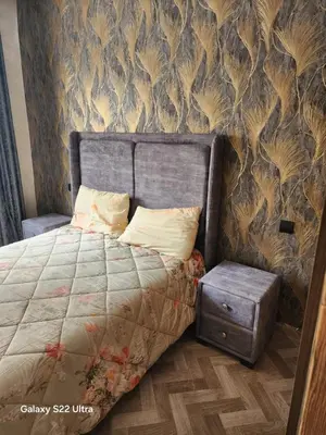 a bedroom with a bed with a nightstand next to it at Appartement ainsbaa in Casablanca