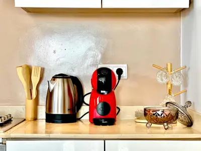 a red coffee maker sitting on a kitchen counter at Magnifique studio cosy et lumineux avec vue sur mer in Tamaris