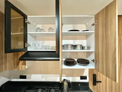 a kitchen with a cabinet with plates and pans at Cosy Central Studio with balcony Maarif - Near Twin Center in Casablanca