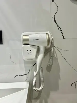 a white hair dryer hanging on a wall at Cosy Central Studio with balcony Maarif - Near Twin Center in Casablanca