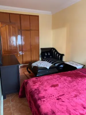 a bedroom with a bed and a cabinet with a red blanket at Bouznika 100m2 Piscineplage in Bouznika