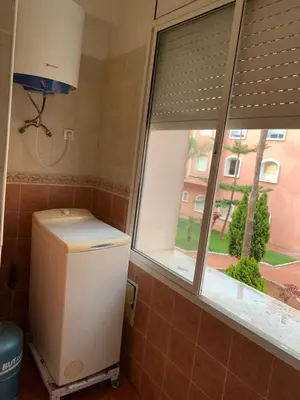 a small refrigerator in a room with a window at Bouznika 100m2 Piscineplage in Bouznika