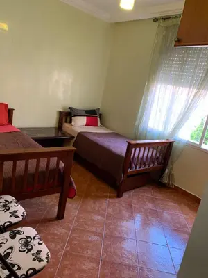 a bedroom with two beds and a window at Bouznika 100m2 Piscineplage in Bouznika