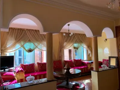 a living room with pink couches and a table at Bouznika 100m2 Piscineplage in Bouznika