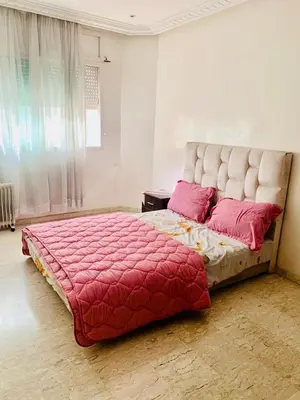 a bedroom with a large bed with red sheets and pink pillows at Rabat Hay Riad 3 Ideal Rooms in Rabat