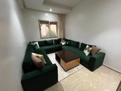 a living room with a green couch and a table at Tamaris Green in Casablanca