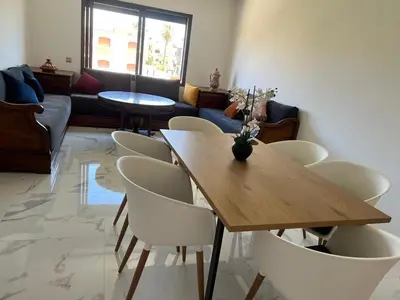 a dining room with a wooden table and chairs at Relaxing Stay 3 Pools & Beach in Sidi Rahal