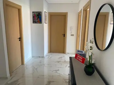 a hallway with a mirror and a table with flowers on it at Relaxing Stay 3 Pools & Beach in Sidi Rahal