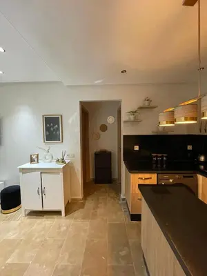 a kitchen with a counter and a white island at Beautiful apartment with pool in Mansouria