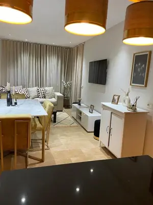 a living room with a couch and a table at Beautiful apartment with pool in Mansouria