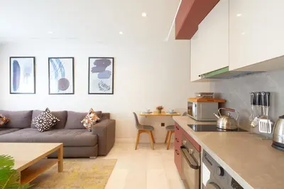 a kitchen and living room with a couch and a table at Beautiful 1 Bedroom in the Center of Casablanca in Casablanca