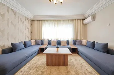 a living room with blue couches and a table at 3 Bedrooms and Room Balcony in Central Casablanca in Casablanca