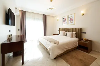 a bedroom with a bed and a desk and a television at 3 Bedrooms and Room Balcony in Central Casablanca in Casablanca
