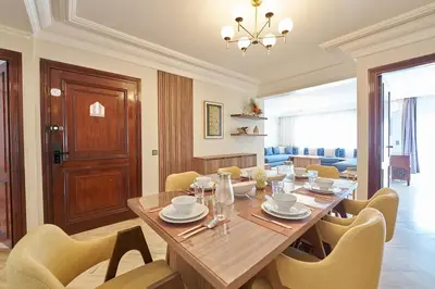 a dining room with a large wooden table and chairs at 3 Bedrooms and Room Balcony in Central Casablanca in Casablanca
