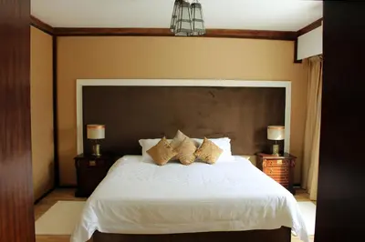 a bedroom with a large white bed with two night stands at Casa Palma Morocco in Sidi Yahia az Zaʼer
