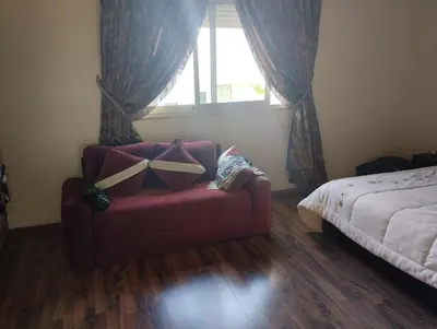 a living room with a red couch and a bed at Magnificent Luxury Beach Villa in Savannah Beach in Dar Hamida