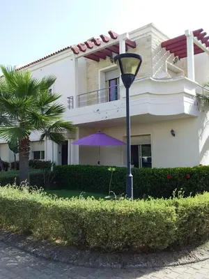 a street light in front of a house with a purple umbrella at Magnificent Luxury Beach Villa in Savannah Beach in Dar Hamida