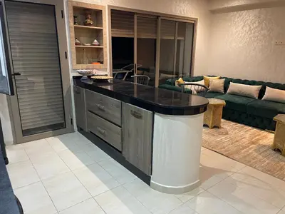 a kitchen with a large island in a living room at Sunny modern Apartment- Ocean & Pool view in Al Mansouria in Mansouria