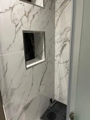 a white marble bathroom with a mirror and a shower at Sunny modern Apartment- Ocean & Pool view in Al Mansouria in Mansouria