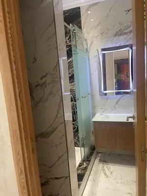 a bathroom with a shower and a sink and a mirror at Sunny modern Apartment- Ocean & Pool view in Al Mansouria in Mansouria