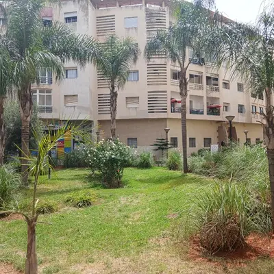 an apartment building with palm trees in front of it at Residence Les jardins de Belvedere in Casablanca