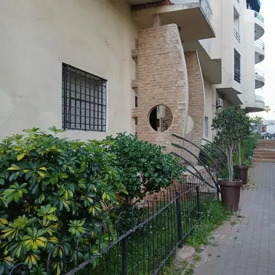a building with a brick fireplace next to a fence at Residence Les jardins de Belvedere in Casablanca
