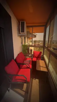 a living room with red couches and a table at Sweethome in Bouznika