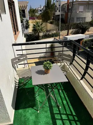 a table and chair on a balcony with a plant at Modern House private Pool, Rooftop & beach view in Mohammedia