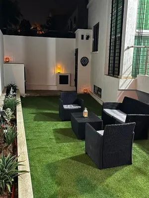 a patio with green grass and couches on a building at Modern House private Pool, Rooftop & beach view in Mohammedia