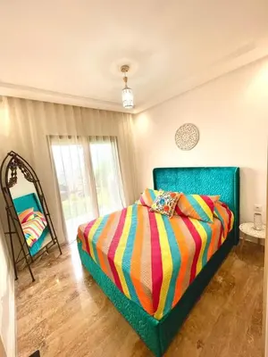 a bedroom with a bed with a colorful blanket at Seaside escape beautiful garden apartment in Sidi Rahal