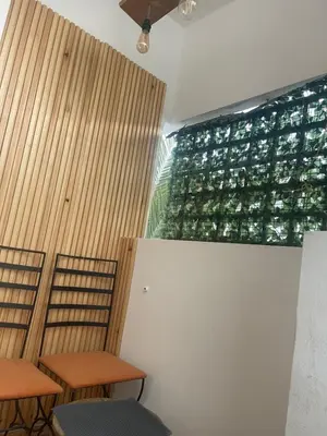 two tables and chairs in a room with a green wall at Nice studio in Rabat
