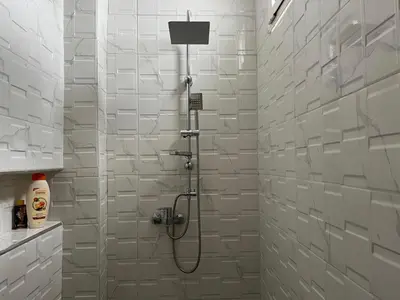 a shower in a bathroom with white tiles at Nice studio in Rabat