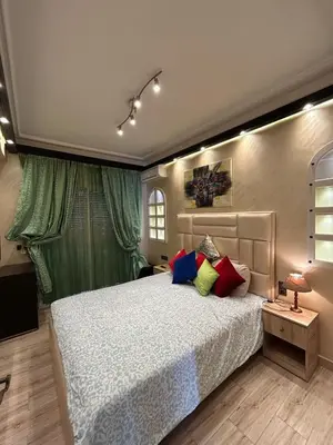a bedroom with a large bed with colorful pillows at Apartment Romandie in Casablanca
