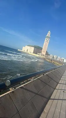 a beach with a clock tower and the ocean at Appartement moderne à Bourgogne 2 chambre in Casablanca-Port