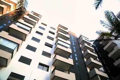 a tall building with palm trees in front of it at Studio haut standing CASA in Aïn Harrouda